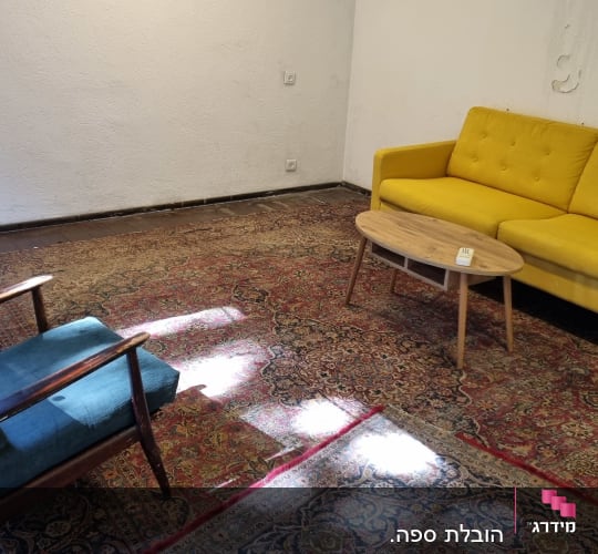 ספה צהובה ושולחן עץ בחדר מגורים